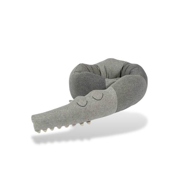 Tour de lit bébé crocodile gris enroulé pour un design pratique et original.