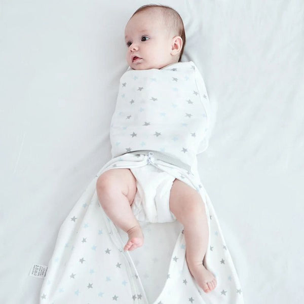 Bébé emmailloté confortablement dans la Gigoteuse d'Emmaillotage Bébé avec un design étoilé.