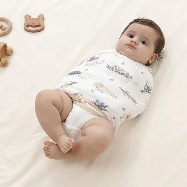 Bébé confortablement enveloppé dans une Couverture d'Emmaillotage d'Été, parfaite pour les journées chaudes.