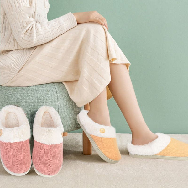 Femme assise avec des chaussons fourrés Femme jaune et une paire rose posée devant elle.