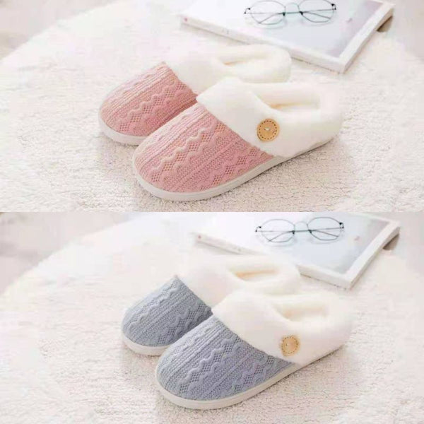 Deux paires de chaussons fourrés Femme en rose et gris posées sur un tapis blanc, à côté d'un magazine et une paire de lunettes de lecture.
