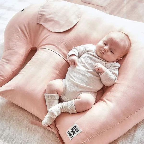 Coussin Bébé Éléphant rose avec un bébé apaisé, illustrant son soutien ergonomique.
