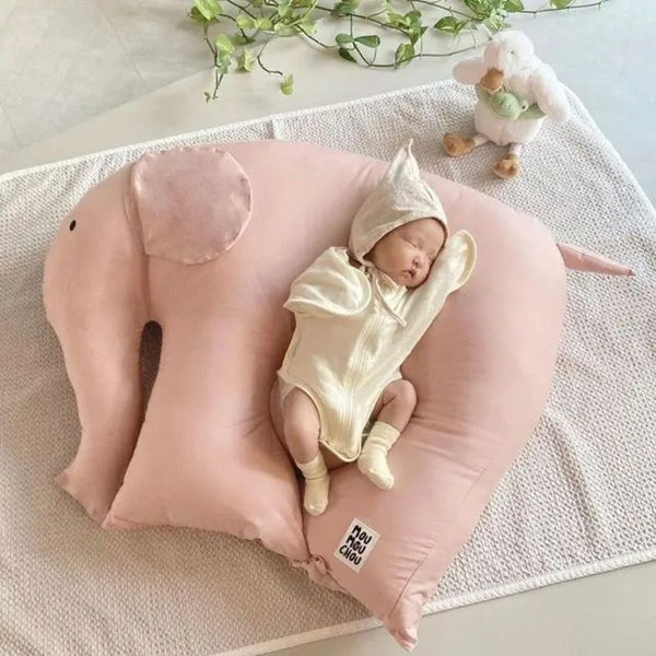 Coussin Bébé Éléphant rose avec un bébé confortablement installé pour des siestes paisibles.