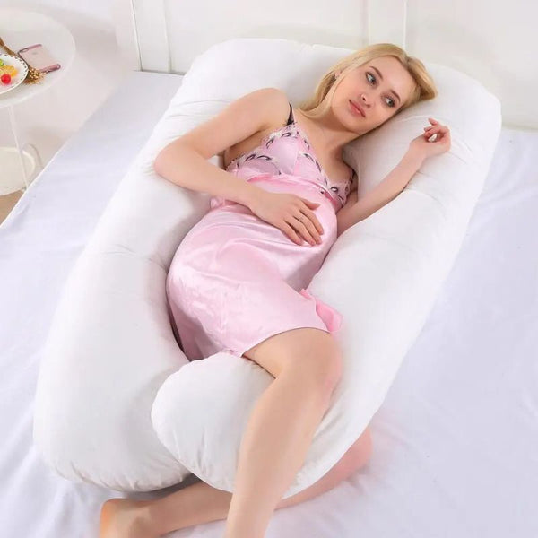 Femme enceinte allongée avec le Coussin de Grossesse U blanc pour un soutien optimal.
