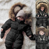 Combinaison Hiver Bébé noire portée par un bébé pour des promenades hivernales stylées et confortables.