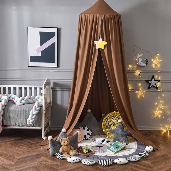 Ciel de lit bébé marron dans un espace de jeu avec des coussins et des décorations étoilées.
