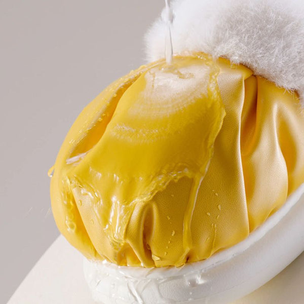 Présentation de la résistance à l'eau des Chaussons Femme Confort jaunes grâce à leur revêtement imperméable.