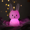 Veilleuse bébé lapin lumière rose apportant une ambiance chaleureuse et apaisante.