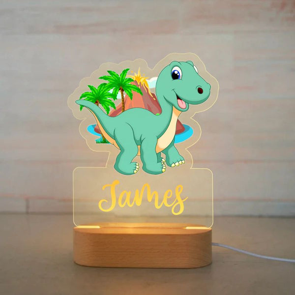Veilleuse bébé personnalisée avec un dinosaure vert et un décor volcanique, prénom James en lumière douce.
