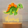 Veilleuse bébé personnalisée avec un Stegosaurus vert et orange, prénom Thomas illuminé.