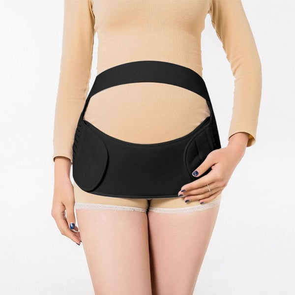 Femme debout portant une Ceinture de Soutien de Grossesse noire pour soulager le dos.