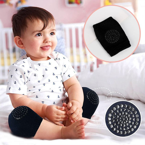 Un bébé souriant portant des genouillères Bébé 4 pattes SafeKneePad en noir.