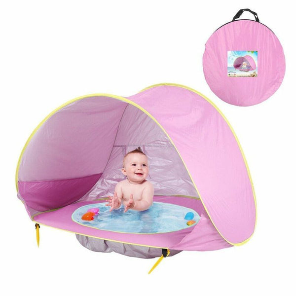 Tente de plage bébé rose avec bassin intégré, sac de transport et accessoires inclus pour une installation rapide.