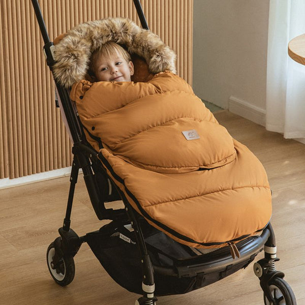 Chancelière universelle évolutive FlexiCocon orange, ajoutant chaleur et confort à la poussette de l'enfant.