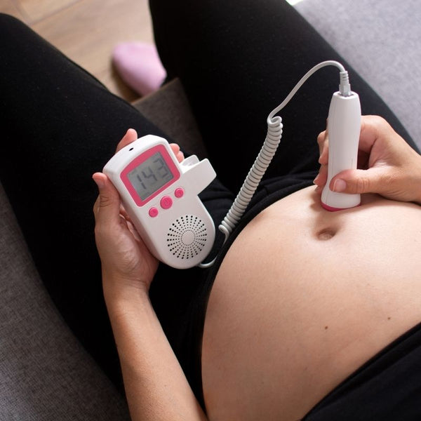Femme vérifiant les battements de cœur de son bébé avec le Doppler fœtal BabyHeartBeat.