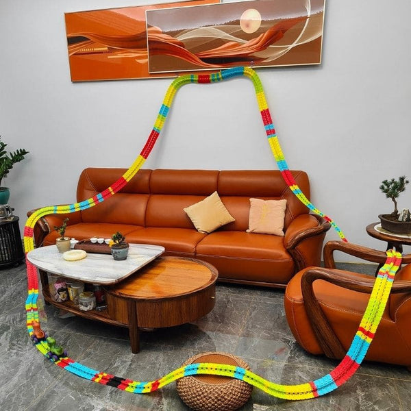 Salon avec canapé en cuir marron, table basse et objets décoratifs, mettant en avant un Circuit Voiture Dinosaure Suspendu coloré - Cocon d'Ange.