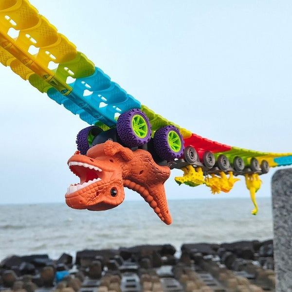 Jouet dinosaure avec un Circuit Voiture Dinosaure Suspendu coloré sur une plage - Cocon d'Ange.