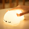 Veilleuse chat tactile s'illuminant sous une pression douce.
