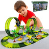 Enfant jouant avec un circuit voiture dinosaure, comprenant des boucles et des dinosaures.
