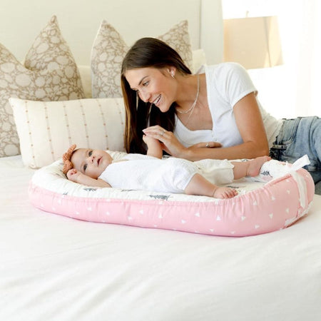 Moment câlin entre maman et bébé avec un Réducteur de Lit Bébé confortable.