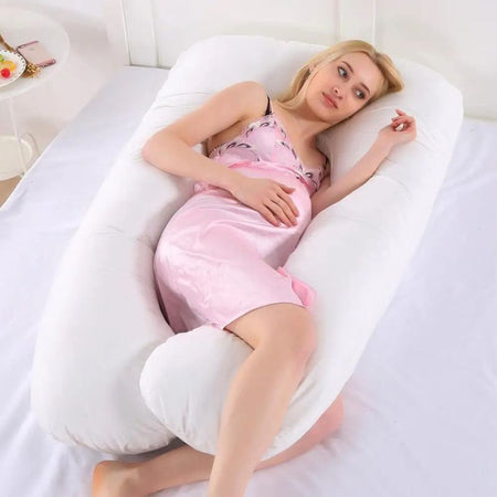 Femme enceinte allongée avec le Coussin de Grossesse U blanc pour un soutien optimal.