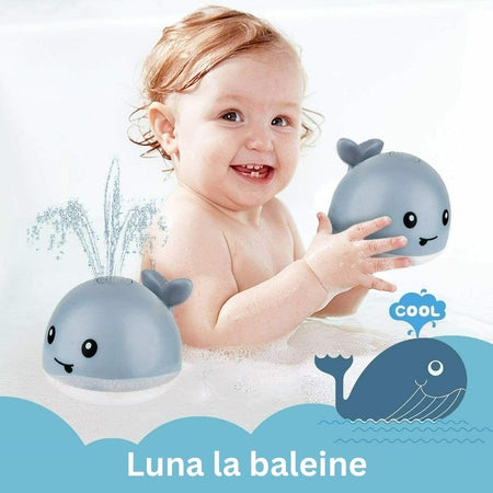 Bébé amusé avec le Jouet de bain bébé Luna la baleine avec lumières LED et jets d'eau.