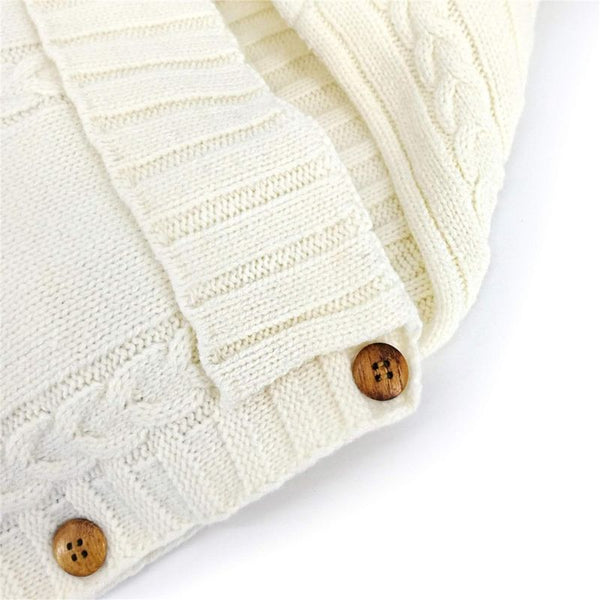 Détails du tricot doux et des boutons du Nid d'Ange Emmaillotage pour un style soigné.