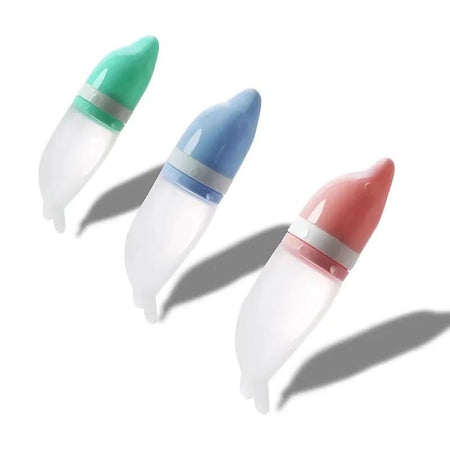 Trois biberons cuillère en silicone aux couleurs pastel : rose, vert et bleu.