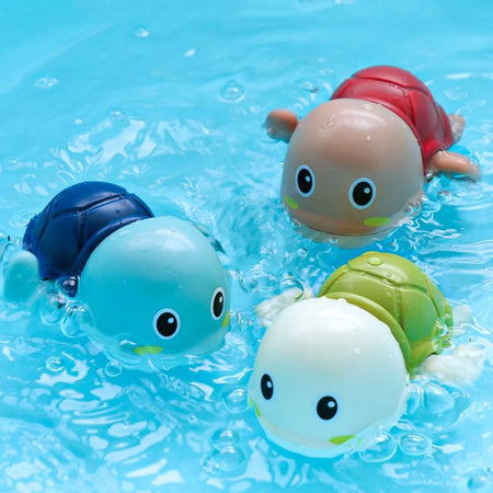 Les jouets de bain bébé Tito la Tortue nagent joyeusement dans une piscine.