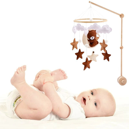 Bébé jouant sous un Mobile Bébé en Bois apaisant et éducatif.
