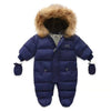 Combi Pilote Bébé bleu marine avec capuche bordée de fausse fourrure marron.