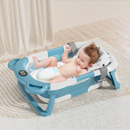 Un bébé souriant dans la baignoire bébé pliable bleu clair avec design moderne.