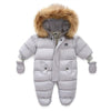 Combi Pilote Bébé grise avec capuche bordée de fausse fourrure marron.