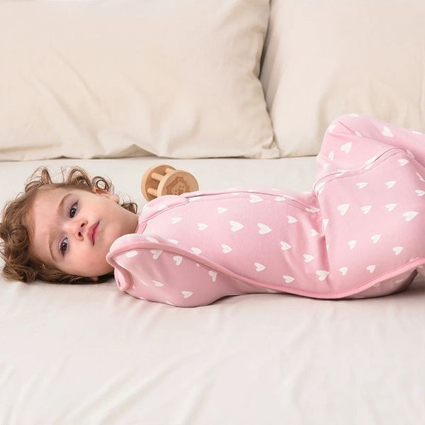 Sécurité et confort réunis dans cette gigoteuse d'emmaillotage rose pour bébé.