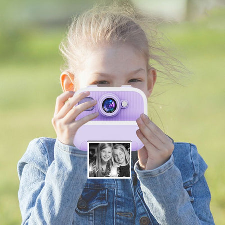 Enfant tenant un appareil photo jouet violet avec un arrière-plan flou - Appareil Photo Enfant Impression Instantanée Sans Encre