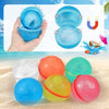 Bombe à eau SplashBall ouverte montrant ses aimants de fermeture, et six bombes colorées posées sur le sable - Cocon d'Ange