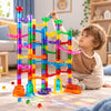 Enfant déposant une bille dans une grande construction BilliTrack avec tubes et parcours colorés - Cocon d'Ange