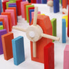 Accessoire moulin en bois DominoBlox placé au milieu d'un parcours de dominos colorés - Cocon d'Ange