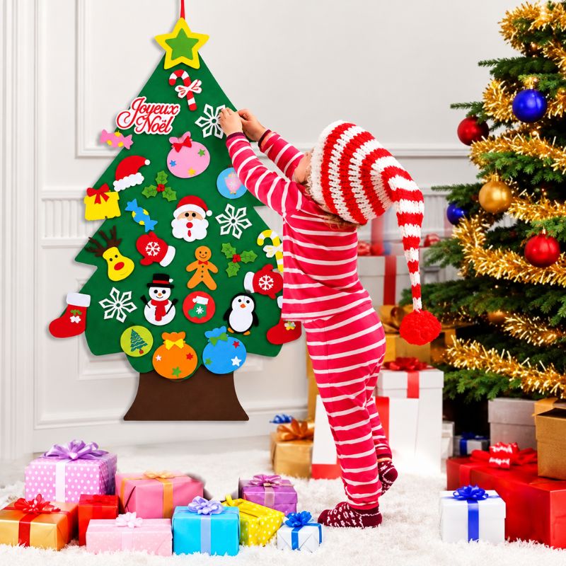 Enfant plaçant les ornements sur un sapin de Noël mural en feutrine MonPetitSapin - Cocon d'Ange